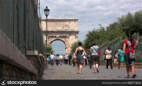 View of an arch of triumph in Rome with tourists