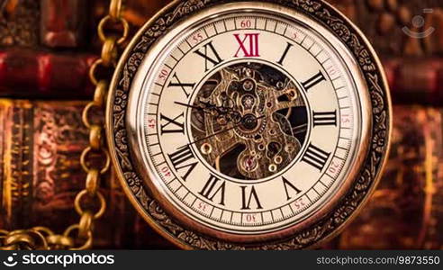 Vintage antique pocket watch against the background of old books