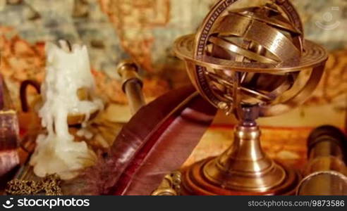 Vintage still life. Vintage magnifying glass lies, pocket watch, old book and astrolabe on an ancient world map in 1565.