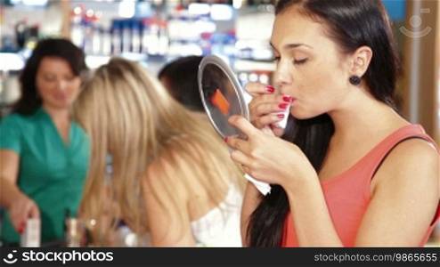 Woman buying cosmetics on sale in beauty department