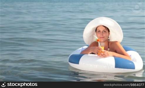 Woman enjoying a cocktail in clear blue water