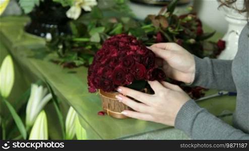 Woman Florist Arranging Valentine's Day Rose Heart Bouquet In Flower Shop Closeup