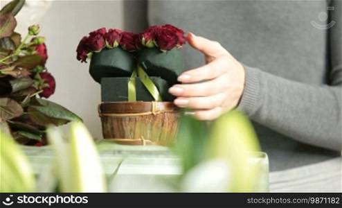 Woman Florist Creating Red Roses Bouquet Arranged in Heart Shape in Flower Shop
