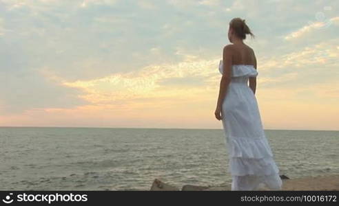 Woman in white dress on the beach