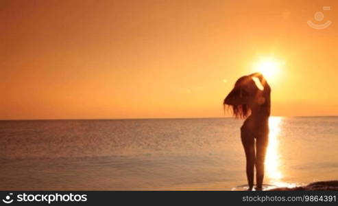 Woman on a quiet beach at sunset