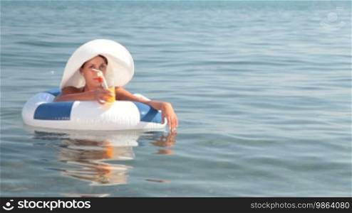 Woman on raft with a cocktail