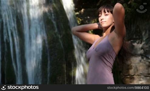 Woman posing by the waterfall