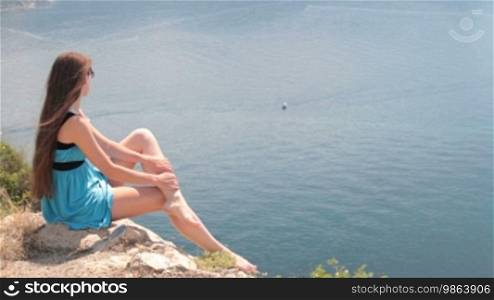 Woman resting on a rock by the sea