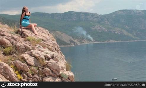 Woman sitting on the edge of a cliff in Balaklava, Crimea, Ukraine