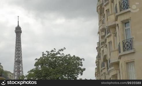 Woman tourist with smartphone making Eiffel Tower shots in retro style and then zooming and looking at photo. Sightseeing of Paris, France