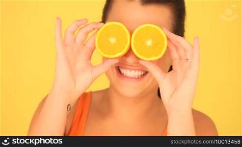 Woman With Orange Eyes, woman playing with orange slices for eyes.