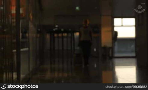 Woman with rolling bag walking at the airport terminal. Going for travel