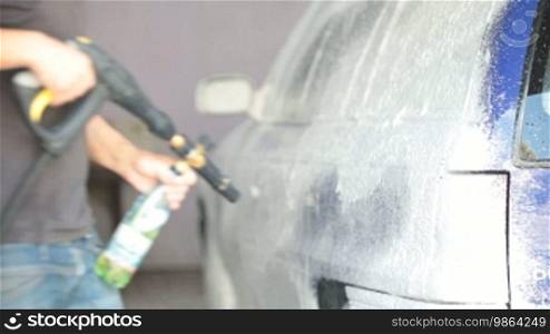 Worker puts on car wash foam