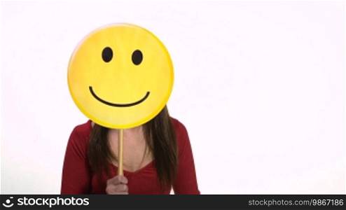 Young blonde Caucasian woman using emoticon icon to express happy feelings and emotions. White background, copy space