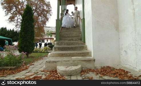 Young Crimean Tatar couple on the steps of the Big Khan Mosque in Bakhchisaray Palace. Bakhchisaray, Crimea, Ukraine Wide Shot