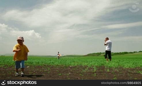 Young Family Playing With Kite In Field