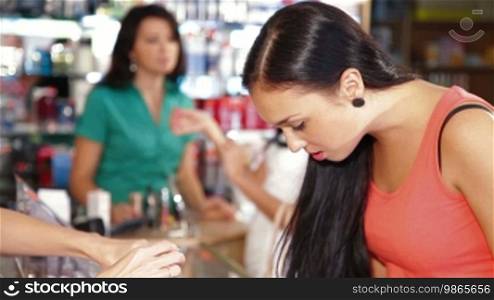 Young Girl Testing and Buying Cosmetics in Beauty Department