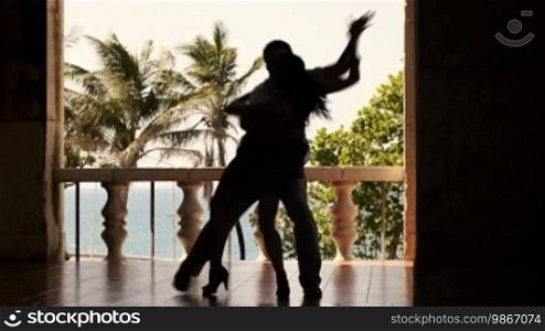 Young Hispanic couple dancing Latin American dance outdoors