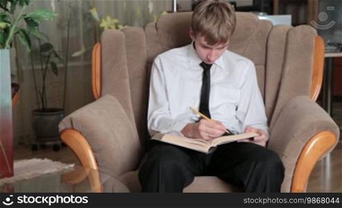 Young man prepares for study in house conditions.