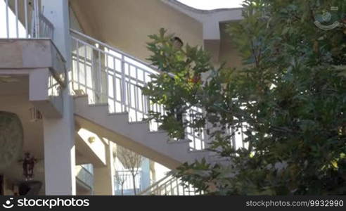 Young man walking down outdoor stairways in hotel or house. He is going to have a training