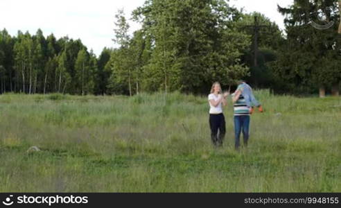 Young parents and their little son walking in the wood together. Father spinning his little child. Outdoor family activities