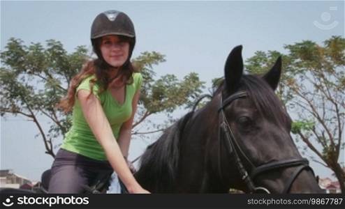 Young people and leisure, lifestyle and fun, travel and vacations, woman on holidays. Pretty girl riding horse, horseback riding, equestrian sports in ranch. Portrait, smiling at camera. 12 of 12
