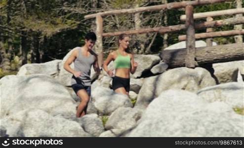 Young people and sport activities, man and woman running on mountain path. Slow motion. Part 2 of 4