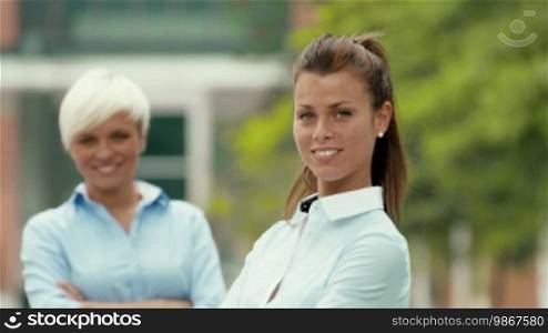 Young people and success, portrait of two young businesswomen smiling and looking at the camera