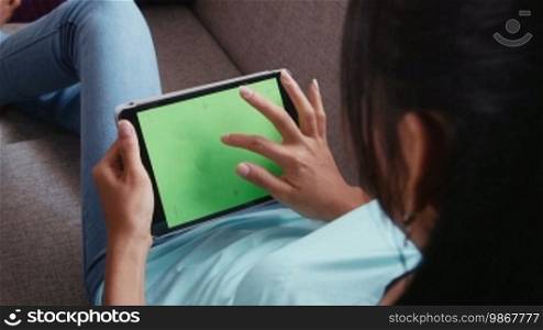 Young people at home, lifestyle and technology, girl, woman using digital tablet computer with green screen for social network, internet and email.