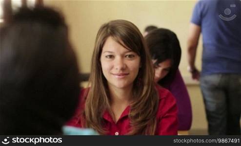 Young people at university, portrait of happy Caucasian teenager smiling during test in college