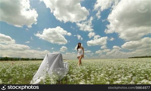 Young Woman Enjoying in White Blossoming Meadow