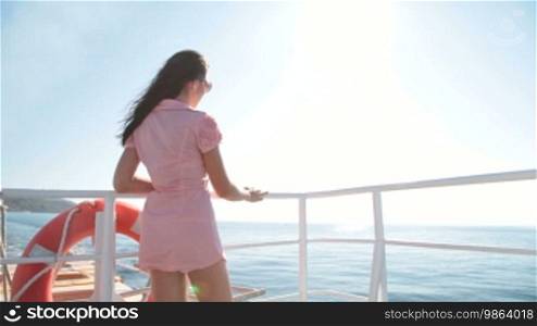 Young woman relaxing on the deck of the sailing ship