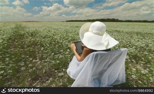 Young Woman Using Digital Tablet In Nature