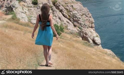 Young woman walking along the seashore in Balaklava, Crimea, Ukraine