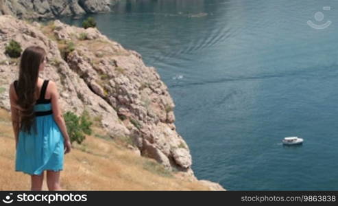 Young woman walks along the seashore in Balaklava, Crimea, Ukraine