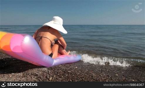 Young woman with white hat relaxing at the beach