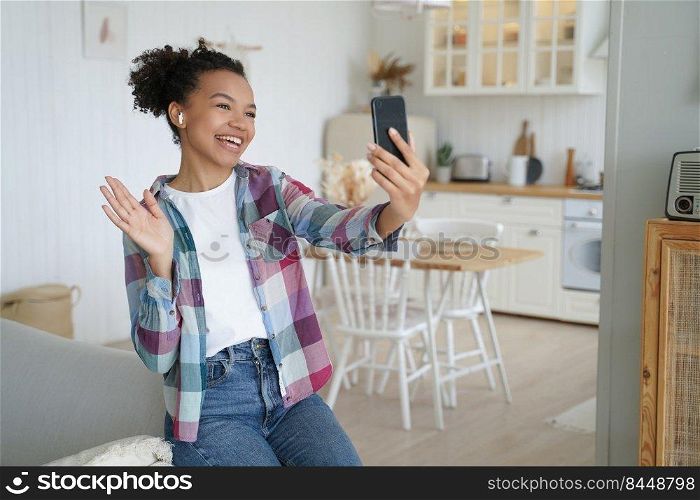 Video phone call. Happy african american woman is talking to friend on smartphone. Teenage girl is holding smartphone and speaking in front of camera, streaming video. Young woman has video chat.. Video phone call. Happy young african american woman is talking to friend on smartphone.