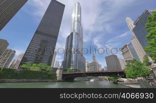 Video timelapse of Chicago downtown skyscrapers at the city center financial district. AMA Plaza, Trump Tower and Michigan Ave Bridge in Chicago city center in the United States of America. Sun reflecting on the skyscrapers glass facades. Tourist and services boats on the river.