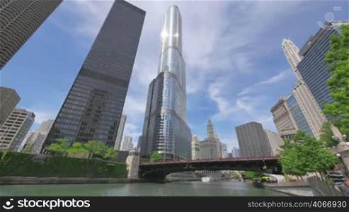 Video timelapse of Chicago downtown skyscrapers at the city center financial district. AMA Plaza, Trump Tower and Michigan Ave Bridge in Chicago city center in the United States of America. Sun reflecting on the skyscrapers glass facades. Tourist and services boats on the river.