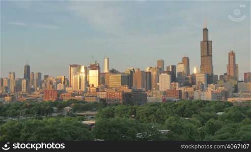 Video timelapse of Chicago downtown skyscrapers from the west of the city center financial district. Awesome Chicago city center skyline at night in the United States of America. Illuminated skyscrapers of Chicago in Spring twilight. Chicago sky in the evenig with the sun on the city sky.