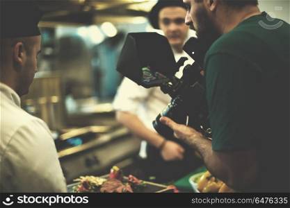 videographer recording while Professional team cooks and chefs preparing meal at busy hotel or restaurant kitchen. videographer recording while team cooks and chefs preparing meal