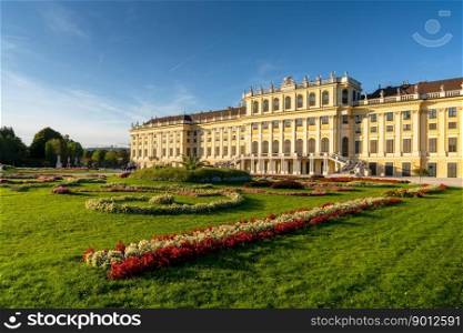 Vienna, Austria - 22 September, 2022: view of the rear of the Schonbrunn Palace with colorful flowers in the gardens in warm evening light