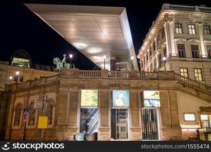 VIENNA, AUSTRIA - November 11, 2015: Lighted facade of Albertina Museum modern building at night on a background of the monument and dark sky in Vienna, Austria.. VIENNA, AUSTRIA - November 11, 2015: Facade of Albertina Museum modern building at night in Vienna, Austria.