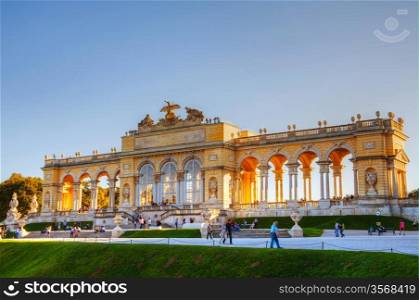 VIENNA - OCTOBER 06: Gloriette Schonbrunn at sunset with tourists on October 06, 2012 in Vienna. It&rsquo;s the largest and most well-known gloriette in Vienna built in 1775 in the garden according to the plans of architect Johann Hetzendorf.