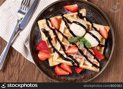 viennese waffles with strawberry and sweet syrup on a plate. viennese waffles with strawberry