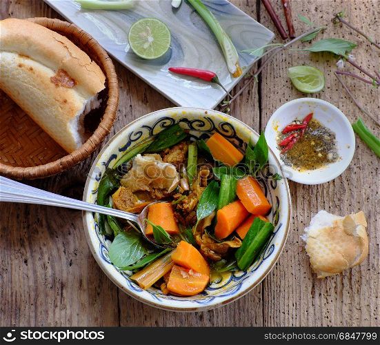 Vietnam food, bread with stewed beef, a popular meal at morning, eat attach parsley, basil, lemon pepper and salt make so delicious taste