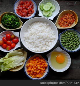 Vietnam food, fried rice, make from rice, egg, sausage, dried shrimp, bean, cucumber, tomato, carrot and scallion, processing with colorful food material on wooden background
