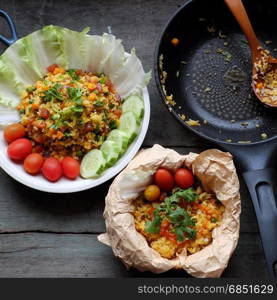 Vietnam food, fried rice, make from rice, egg, sausage, dried shrimp, bean, cucumber, tomato, carrot and scallion, high view of dishl on wooden background