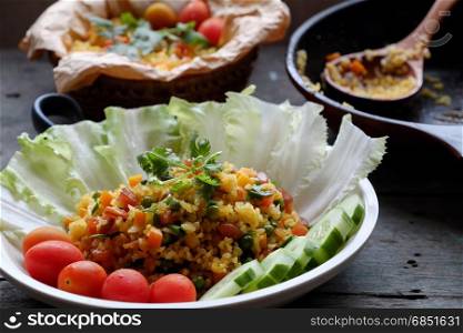 Vietnam food, fried rice, make from rice, egg, sausage, dried shrimp, bean, cucumber, tomato, carrot and scallion, close up of dish on wooden background
