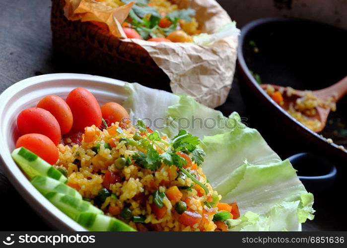 Vietnam food, fried rice, make from rice, egg, sausage, dried shrimp, bean, cucumber, tomato, carrot and scallion, close up of dish on wooden background